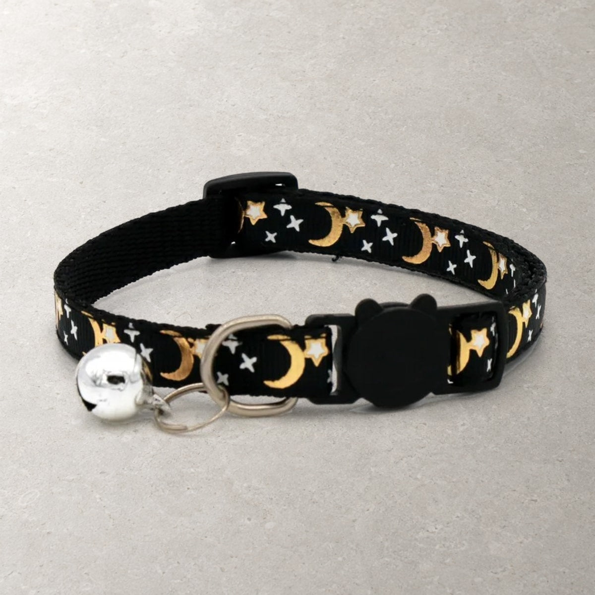 Black breakaway cat collar with gold moons and white stars, black cat-face buckle and silver bell